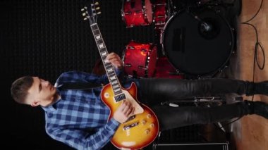 Gitarist müzik stüdyosunda elektro gitarda rock şarkısı söylüyor. Gitarda akor çalan profesyonel bir müzisyen, ses kayıt stüdyosunda prova yapıyor. Dizi enstrümanları çalınıyor