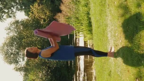 Mujer Descalza Pie Hierba Verde Rodando Estera Yoga Vídeo Vertical — Vídeo de stock