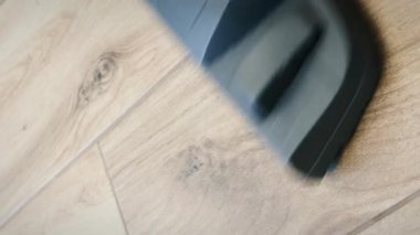 Dairenin zeminini elektrikli süpürgeyle temizleyen bir kadın. Dikey video. Yerleri elektrikli süpürgeyle süpüren bir kadın. Ev elektroniği ve ekipmanı