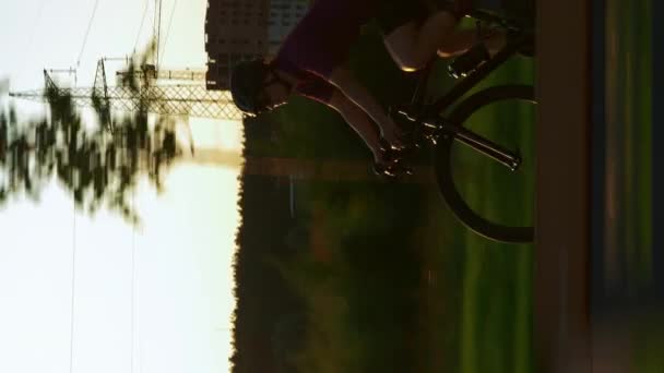 Kerékpárosok Bicikliznek Naplementekor Női Atléta Biciklizés Függőleges Videó Kerékpáros Ruházat — Stock videók
