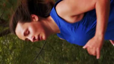 Dışarıda koşan bir kadının portresi. Dikey video. Spor elbiseli bir kadın sabah ormanda koşuyor, yoğun kardiyo egzersizleri yapıyor. Spor eğitimi. Sağlıklı yaşam tarzını sürdürmek