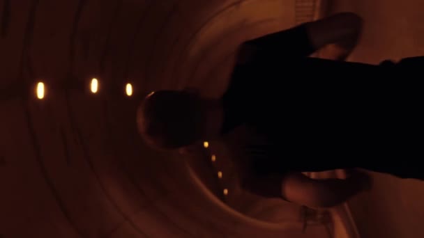 跟在后面的是一个人在空旷的路上在黑暗的隧道里跑步的镜头 垂直录像 强壮健康的男子跑步者夜间在室外训练 通过隧道慢跑 运动动机 健身活动 — 图库视频影像