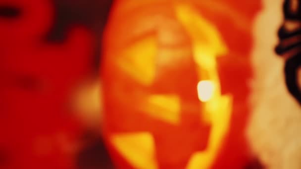 中のろうそくを点灯する恐ろしいカボチャの顔の近く バーティカルビデオ ホラーハロウィーンパーティー ハロウィンのお祝い カボチャで飾られたテーブルの背景 — ストック動画