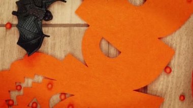 Ahşap arka planda yarasalar ve Cadılar Bayramı süslemeleri. Cadılar Bayramı Konsepti. Cadılar Bayramı partisi kutlaması. Balkabakları, örümcekler, yarasalar, iskeletler ve örümcek ağları. Dikey video
