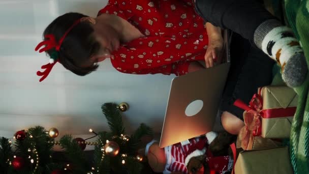 Aantrekkelijke Brunette Kerstfeestkleding Die Naast Kerstboom Zit Computer Werkt Nieuwjaarsavond — Stockvideo
