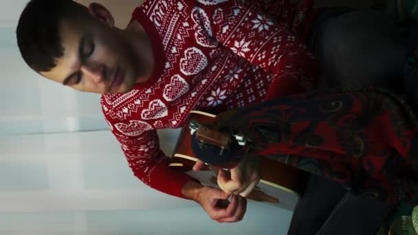 Junger Mann Spielt Akustikgitarre Sitzt Weihnachtsbaum Singt Lieder Und Feiert — Stockvideo