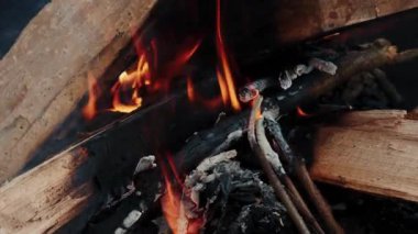Barbekü ızgarasında yanan kömür. Çalı ağaçları yanmaya başlıyor. Şenlik yemeği pişiriyorum. Barbeküde yanan alevler. Izgaradaki ağaç dallarından ateş yakın.