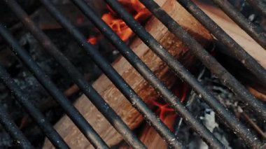 Ateşin içinde yanan odun. Barbekü ya da ızgara hazırlıyorum. Yakacak odun ızgarada yanıyor. Bahçede alevler içinde yanan kömürler. Izgara sezonu