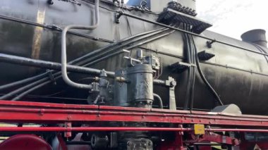 Buharlı klasik lokomotif. Alman retro motor lokomotifi yolculuğa hazırlanıyor. Eski yolcular tren istasyonunda eğitim görürler. Buhar motorlu Retro lokomotif