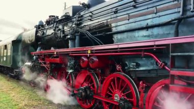 İşletim mekanizmalı tarihi buhar makineli tren lokomotifi. Eski Alman kömür buharlı lokomotifi tren istasyonundan ayrılmaya hazırlanıyor. Tarihi vintage ulaşım