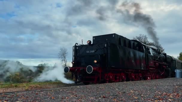 ヴィンテージの石炭蒸気機関車で トレイルで煙が出ている レトロ輸送と旅行 鉄道駅のドイツの歴史的な列車 鉄道トラックでたくさんの蒸気を持つ古いレトロエンジン列車 — ストック動画