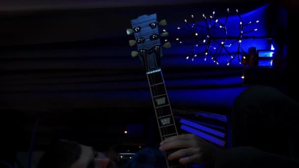ロマンチックな若者が電気ギターを持って 明かり付きの暗い部屋でロックバラードソングを演奏します 新しい歌を演奏するミュージシャン 音楽楽器コンセプト バーティカルビデオ — ストック動画