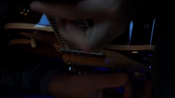 男人在黑暗的房间里手弹电吉他 男性的手和吉他弦与皮卡演奏摇滚歌曲 音乐概念 音乐家在电吉他上练习新的歌曲 垂直录像 — 图库视频影像