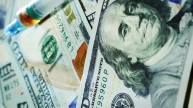 Amerikan doları geçmişi. Nakit para ve şırınga masada. Amerikan doları banknotları. Yüz dolarlık banknot. İş için. Uyuşturucu bağımlılığı konsepti. Nakit para banknotları. Finans konsepti. Dikey video