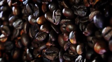 Kahve çekirdeği arka planı, yakın çekim. Kavrulmuş dumanlı kokulu kahve çekirdekleri kahve çekirdeklerinden gelir. Masada dönen arap kahvesi tanecikleri. Dikey video