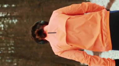 Ormanda koşan bir kadın. Genç motive olmuş bir kadın günlük idmanın bir parçası olarak dışarıda spor yapıyor. Formda profesyonel koşucu sıkı antrenmanı ve koşu yarışına hazırlık. Dikey video