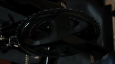 Yarış motoru sistemi ve durağan bisiklet eğitmeni. Kapalı alanda pedal çeviren akıllı bisiklet eğitmeni. Zincir, zincir, akıllı sabit bisiklet eğitimi. Bisiklet. Dikey video