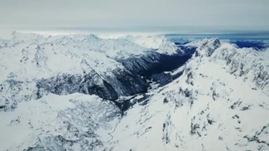 İsviçre 'deki Titlis Dağı, Engelberg. Arkasında karlı kayalık dağlar olan İsviçre Alpleri manzarası. Karlı dağ zirveleri ve sıradağlarıyla resmedilmiş kış manzarası. Kış etkinliği