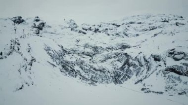 Taze karla kaplı dev dağ zirveleri. Titlis Dağı, Engelberg, İsviçre Alpleri. Karlı kayalık dağ zirveleri teleferikle yapılıyor. Kış sporu aktivitesi. Popüler seyahat yerleri. İsviçre dağları