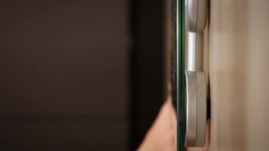 İnsan ayağı terazinin üzerinde duruyor, yaklaş. Ağırlık ölçen bir kadın. Kilo verme konsepti. Akıllı vücut tartıları. Dikey video