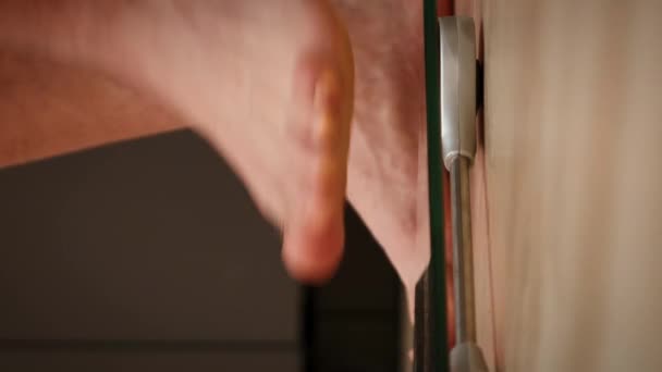 人間はスケールを測るのに足を踏み入れた 体重を測定する男性の足 スケールの上に立っている人間 閉じる フロントビュー バーティカルビデオ — ストック動画