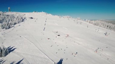Kış sporu aktivitesi. Almanya 'da popüler kayak merkezi Feldberg. Güneşli kış gününde kayak ve kar kayağı yapan insanlar. Kış turizmi. Kayak ve snowboardlarda tepetaklak giden aktif insanlar