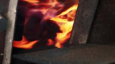Yakacak odunları olan odun sobası. Şöminede ateş yanıyor. Tahta ve ateş dolu gerçek bir odun fırını. Dikey video