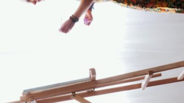 Modern evde soyut resim üzerinde çalışan yetenekli bir kadın sanatçı. Güneşli bir günde evde tuvale resim çizen genç bir kadın. Sanat ve resim konsepti. Dikey video