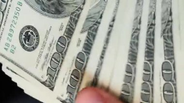 Zengin ve başarılı kişi ofiste nakit para sayıyor. Adam dolarları sayıyor. Elinde para tutan kişi. 100 Amerikan dolarına yakın banknotlar. Başarı konsepti. Dikey video