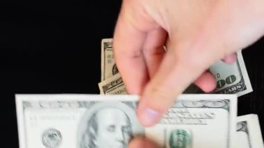 100 Amerikan doları banknot yığınını elinde tut. Nakit para sayan kişi. Ofiste para sayan bir adam. Başarı ve kazanma kavramı. Finans ve iş. Dikey video