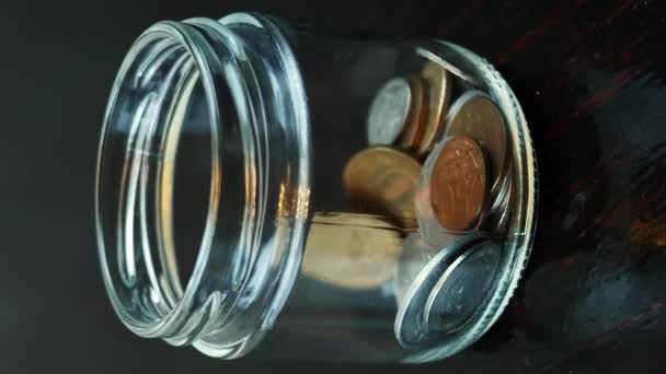 コインをガラス瓶に投げ込み 閉じる お金の概念を節約する 世界経済 貧困という概念 金融危機 貯金するガラス瓶 貯金して お金を稼ぐ バーティカルビデオ — ストック動画
