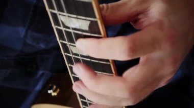 Gitarda çalan adam, panoyu kapat. Gitarist elektro gitarda şarkı ve solo söylüyor. Profesyonel gitar çalıyor. Adam gitar çalmayı öğreniyor. Müzik konsepti. Dikey video