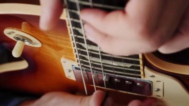 Gitarda çalan insan parmakları. Gitar panosunu kapat ve erkek eli akorları çal. Profesyonel gitar solosu. Öğretmenle müzik dersleri. Telli müzik enstrümanlarıyla çalıyorum. Dikey video