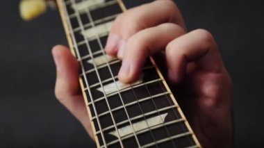 Elektro gitarda tellerle çalan bir müzisyen. Gitarist gitar çalışıyor, akor öğreniyor. Adam müzik enstrümanı çalıyor. Erkek müzisyen yeni şarkısını söylüyor. Müzik konsepti. Dikey video