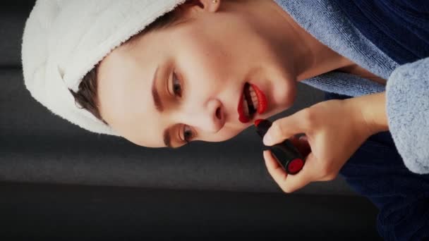 涂口红的女人女性在家里做迷人的模特化妆 迷人的女人在嘴唇上涂上红色口红 漂亮的女人在化妆 化妆的过程中 垂直录像 — 图库视频影像