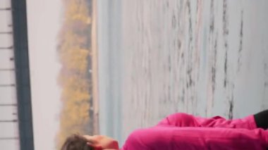 Arka taraf, sabah tek başına nehir ve şehir parkında yürüyüş yapan tombul kızın manzarasını takip ediyor. Açık havada inşaat eğitimi almış, kilo vermeye çalışan bir kadın. Fitness. Dikey video