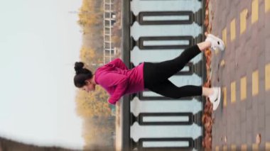 Açık havada koşan, kilo vermeye çalışan iri yapılı genç bir kadının yan görüntüsü. Tombul kadın yoğun fitness kardiyo egzersizleri yapıyor. Egzersiz. Sağlıklı bir yaşam tarzı. Dikey video