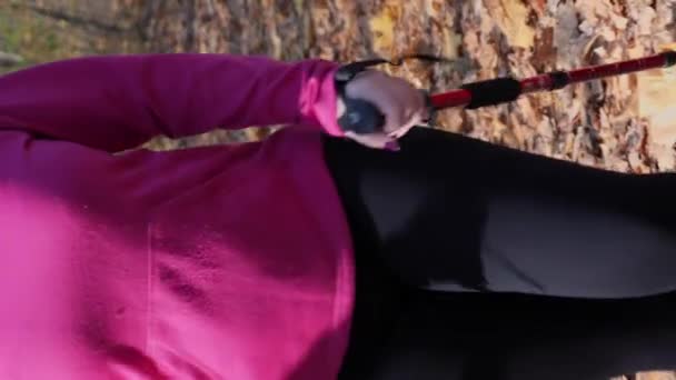 在秋天的公园里 有动力的 有北向步行杆的女运动员正在进行有氧运动密集训练 垂直录像 年轻的胖胖的女性在室外锻炼 试图减肥 健身锻炼活动 — 图库视频影像