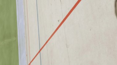 Hızlı giden profesyonel bisikletçiler, bisiklet tekerlerini kapatıyorlar. Bisiklet pistinde antrenman. Açık velodromda bisiklet yarışı. Spor bisiklet konsepti. Dikey video