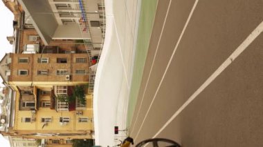 Pist bisikletçisi, açık Velodromda sabit vitesli bisiklete binmeye başlamaya yardım ediyor. Bisiklet pisti. Dikey video