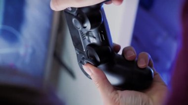 Evde video oyunu oynuyorum. Kablosuz joypad 'i tutan ve tuşlara basan eller. Dikey video