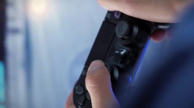 Video oyunları. Geniş ekran TV 'nin önünde oyun konsolunda oyun oynayan erkek ellerini kapat. Erkek, oyun oynamak için kablosuz kumanda kullanıyor. Dikey video