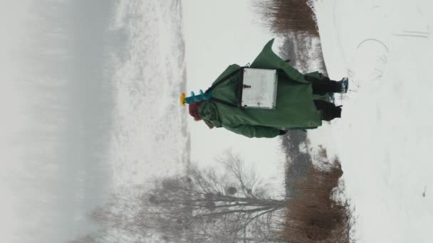 Рыбак Дрелью Плече Человек Идет Через Замерзшую Реку Зимней Рыбалке — стоковое видео