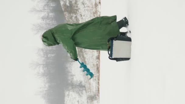Ледяная Бура Делает Ледяную Дыру Замерзшей Реке Рыбак Сверлит Ледяное — стоковое видео