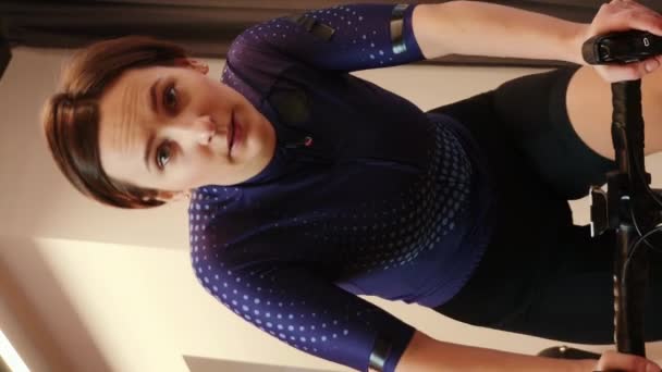 骑自行车的女运动员对聪明的自行车教练要求很高 女人在骑固定自行车训练 垂直录像 — 图库视频影像