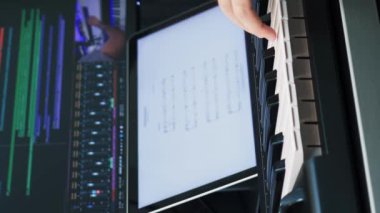 Evde müzik stüdyosunda elektrikli Midi klavyesinde piyano çalan eller. Müzisyen şarkısı, bilgisayarın önünde piyano çalıyor. Dikey video