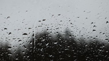 Akan yağmur damlalarıyla saydam cam zemin bulanıklığı. Yağmur damlaları yağıyor. Fırtınalı yağmurlu hava