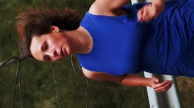 Ormanda boş bir yolda koşan motive olmuş kendine güvenen bir kadının portresi. Bayan sporcu, dışarıda egzersiz yapıyor. Dayanıklılık antrenmanında bir sporcu dağlarda koşar. Dikey video