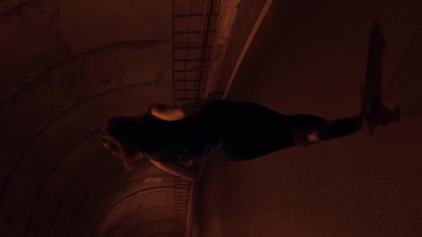 トンネルに沿って走っている女性は 後ろに撃たれます トンネルを走る女性アスリート アウトドアジョギングトレーニング バーティカルビデオ — ストック動画