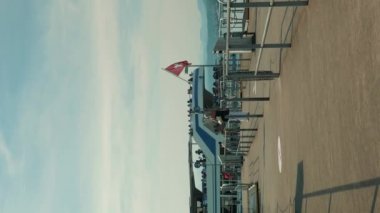 Yelkenli yelkenli beyaz gemisiyle iskele İsviçre bayrağını sallıyor. Zürih, İsviçre, 14.08.22. Güneşli yaz gününde ünlü Zürih Gölü. Dikey video